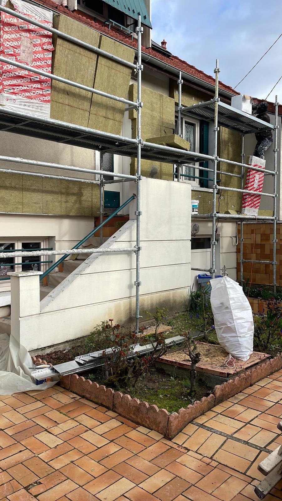 Pose de panneaux isolants en laine de roche sur une façade