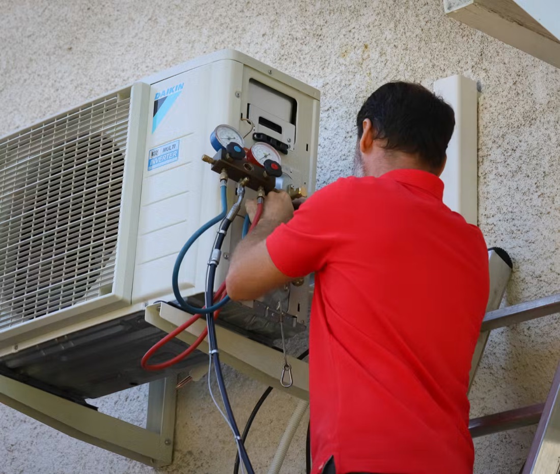 Technicien intervenant sur l'unité extérieure d'une pompe à chaleur air-air